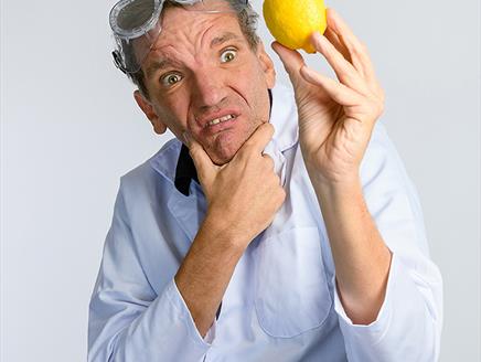 Henning Wehn wearing science goggles holding a lemon