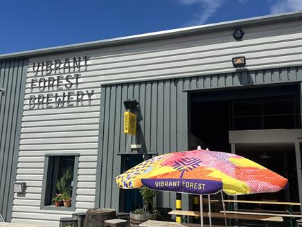 Picnic bench and colourful umbrella outside of the Vibrant Forest Brewery