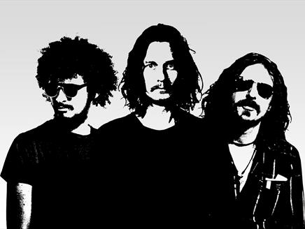 Three men stand together in black and white.