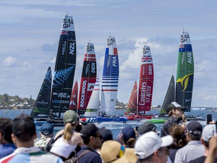 Image of F50 catamarans racing on water with crowd watching in the foreground