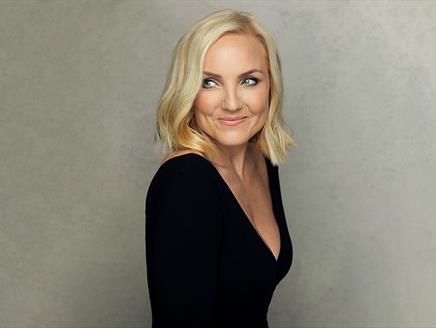 Photograph of Kerry Ellis for Queen of the West End, showing the singer in a black dress against a grey background