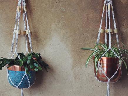 Photograph of two Macrame Pot Hangers on a wall