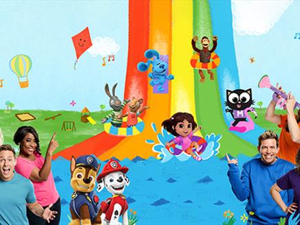 A rainbow slide with a host of Milkshake! characters on a rainbow slide and six of the presenters either side