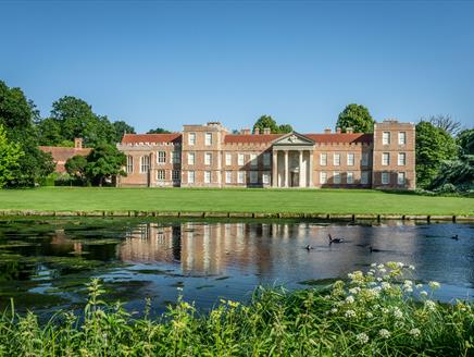A view of The Vyne house and north lawn from across the lake.