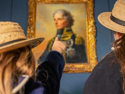 Children taking in a painting of Nelson at Portsmouth Historic Dockyard