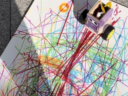 A coded robot draws on a piece of paper