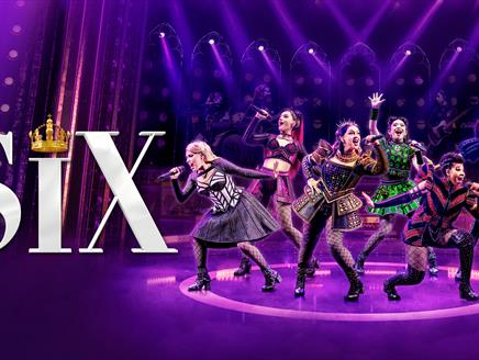 Six women singing on a purple stage