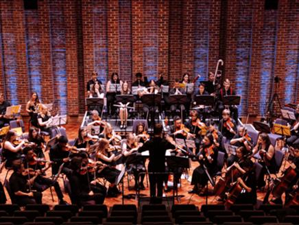 A student orchestra performs on the Turner Sims stage.