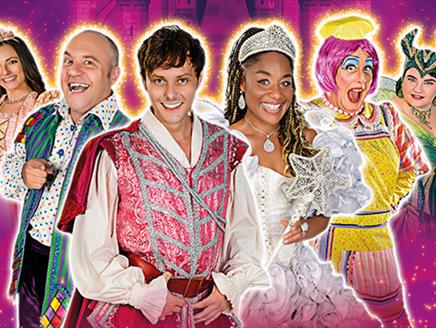 Six cast members from Sleeping Beauty in vibrant costumes, all looking at the camera on a pink sparkly background