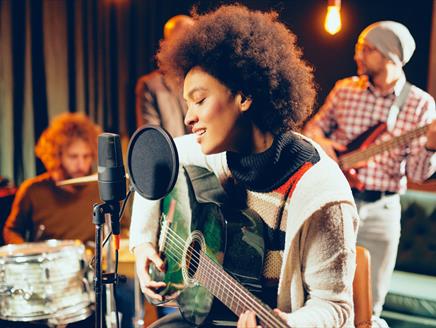 A woman singing with people in the background