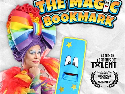 A pantomime dame in rainbow jacket and wig is holding a soft blue bookmark with yellow ribbing and big cartoon eyes. The background is crumpled paper.