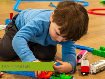 Young Toddler playing with toy train on tracks at October half term event held at Sky Park Farm.