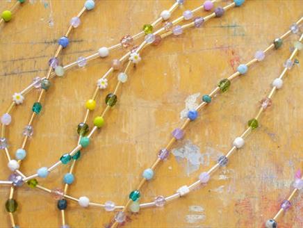 A number of beaded necklaces with different coloured beads.