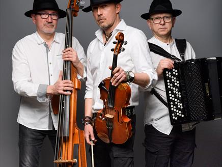 Jerzy Bawol, Tomasz Kukurba and Tomasz Lato hold their instruments and look towards the camera.