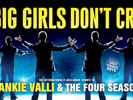 Silhouettes of four men stand on a stage facing the audience