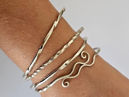 Set of decorative silver stacking bangles on wrist