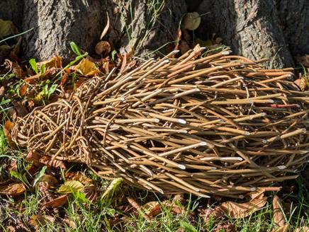 Willow hedgehog sculpture in front of a tree