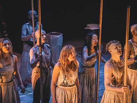 A group of seven actors dressed in rags most holding sticks. From a production of Macbeth.