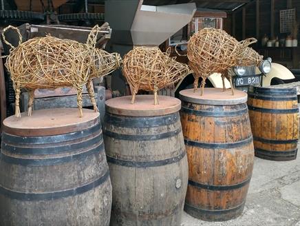 willow piglet sculptures on cider barrels