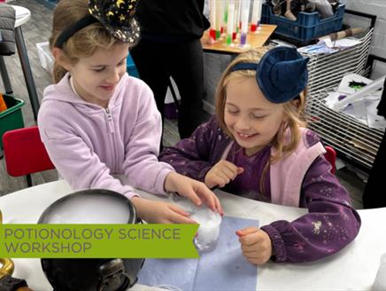 Young Girls at Potionology Science Show at Sky Park Farm with cauldron of dry ice and potion mixing.