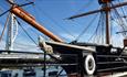 The exterior of HMS Warrior with the Spinnaker Tower in the distance