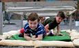 Boys crawling under obstacle on Fort Nelson's assault course