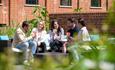 A group of people sat outside at Bombay Sapphire Distillery drinking cocktails