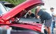 Classic car enthusiasts looking under the bonnet of a vehicle at Port Solent