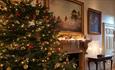 Inside one of the rooms at Stansted House, decorated for Christmas with a tree by the fireplace