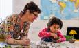 Image of Community Takeover at John Hansard Gallery showing a tutor teaching a child how to sculpt clay.