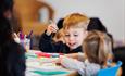 Image of Community Takeover at John Hansard Gallery showing a creative workshop with children colouring in with felt tip pens.