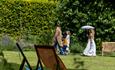 People in period costume strolling through the grounds of Jane Austen's House, Chawton.