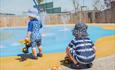 Splashpad - children play pool - two children playing