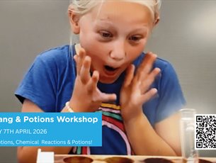 Young Blond girl looking happily excited at a test tube bubbling from a lava experiment at an event.