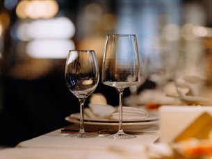 Two wine glasses sat on a neatly set table