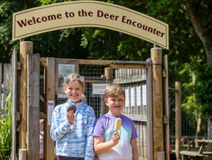 Two children enjoying an ice cream outside the deer encounter walk through area