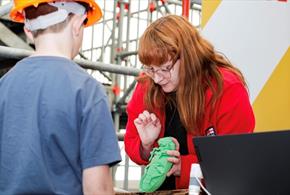 A woman showing a child one of the pests which could impact the ship.