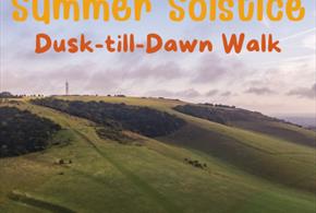 An image of Butser Hill as the sun sets with Summer Solstice Dusk-till-Dawn walk written in the horizon