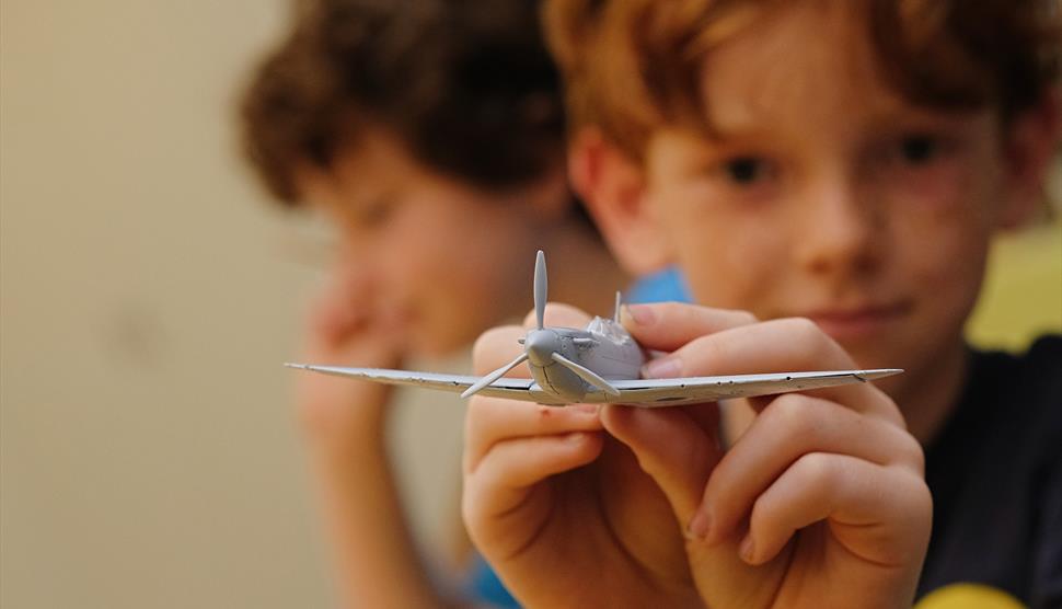 Boy at The D-Day Story showing off an Airfix model of an aeroplane - credit Matt Scott-Joynt