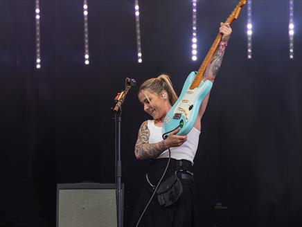 Lucy Spraggan playing guitar on stage