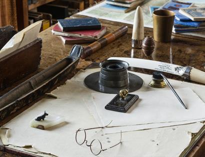 a writing desk with circular spectacles and items of stationery.