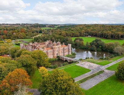 Aerial view of Herstmonceux Castle estate surrounded by lakes, woodland and countryside in East Sussex.