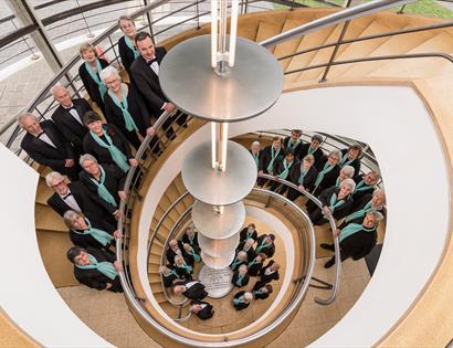 birds eye view of choir members stood around a spiral staircase.