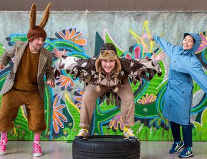 Promotional image for “Animals!” featuring performers in animal costumes against a colourful woodland backdrop.