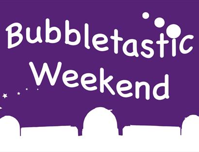 poster. purple background. Bottom has white silhouette of herstmonceux observatory domes. Text says bubbletastic weekend.