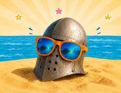 Medieval helmet wearing sunglasses on a sandy beach by the sea, promoting the “1066: Swords & Sandcastles” pop‑up event.