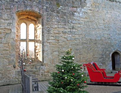 old castle wall with red santa sleigh and christmas tree