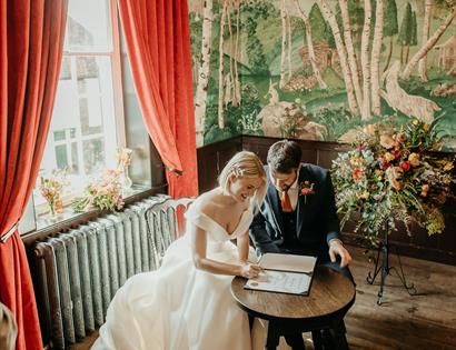 photograph of bride and groom signing a marriage register at The Bell in Ticehurst