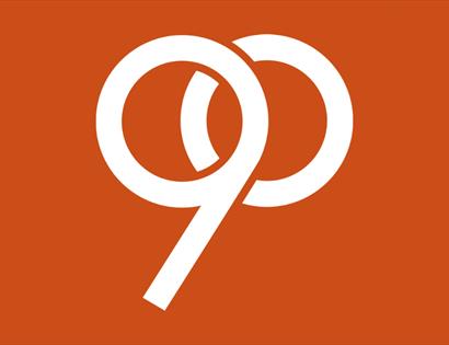 90th anniversary mark for the De La Warr Pavilion designed by Tom Geismar on an orange background. 