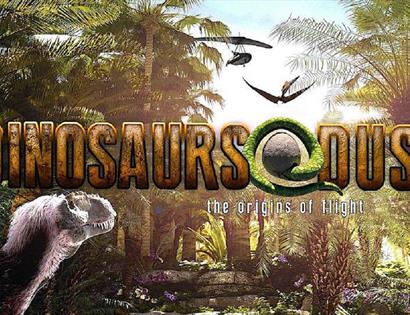 Picture shows an image of a rainforest with multiple dinosaur figures in view. Writing says: "Dinosaurs @ Dusk, the origins of light"